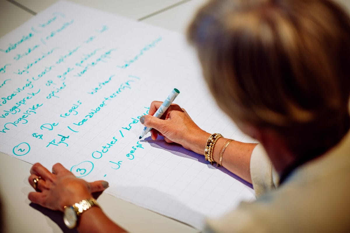 Vrouw schrijft ideeen op op tweede kennisdag